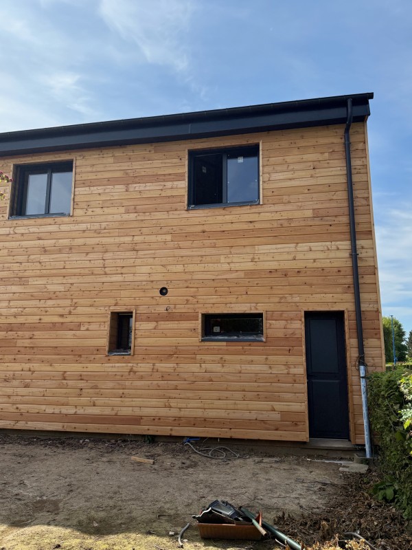 Bardage d'une maison et d'un agrandissement en bois Mélèze avec isolation proche de Fécamp en Seine-Maritime